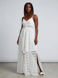 Woman wearing a white crochet lace boho maxi dress in a studio setting