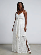 Woman wearing a white crochet lace boho maxi dress in a studio setting