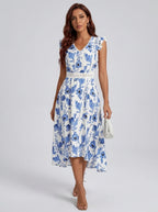 Woman wearing a blue and white floral print midi dress in a studio setting
