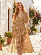 Woman wearing an olive green and pink floral print boho kaftan maxi dress on a sunny street