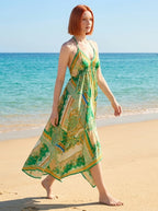 Woman wearing a green paisley print halter maxi dress on a sunny beach