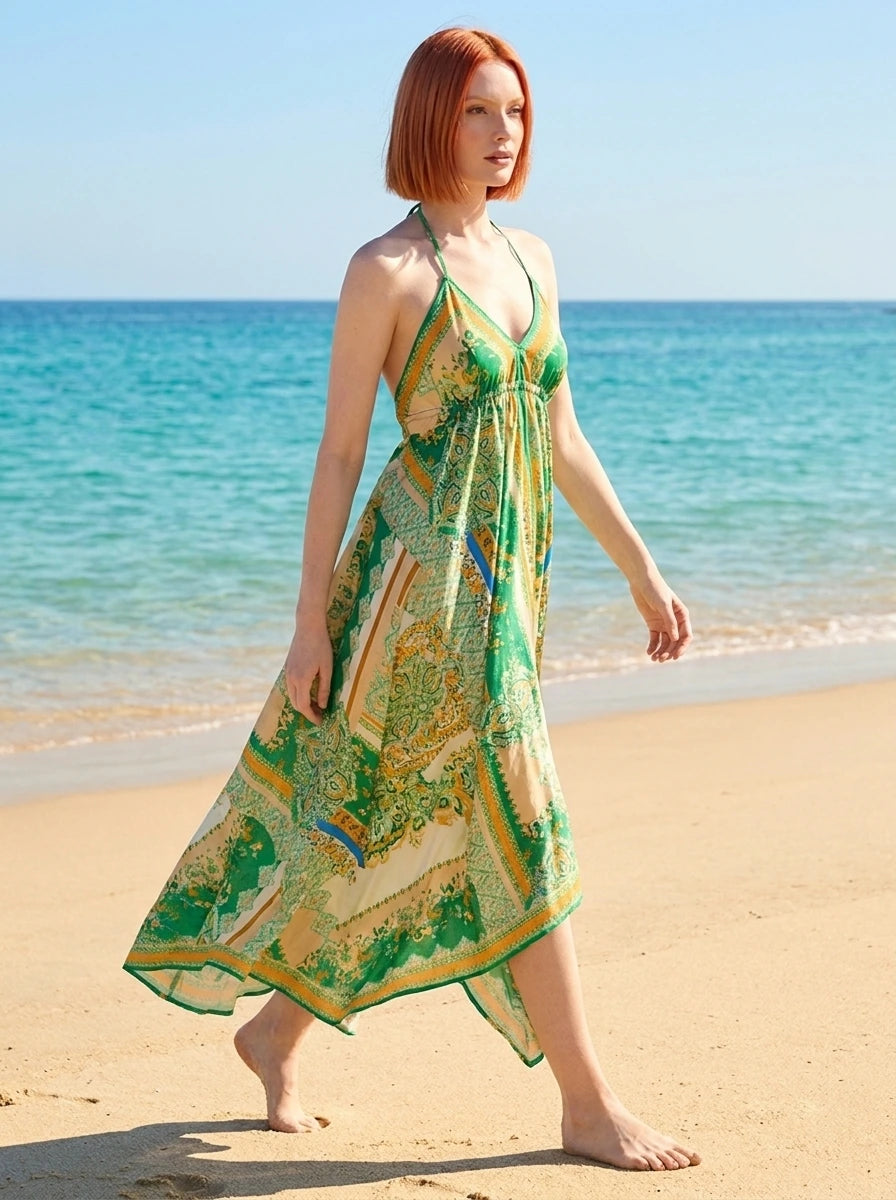 Woman wearing a green paisley print halter maxi dress on a sunny beach