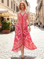 Woman wearing a pink paisley print halter maxi dress on a sunny street