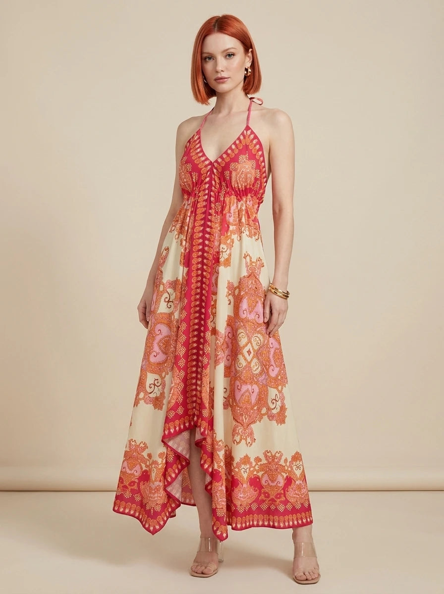 Woman wearing a red paisley print halter maxi dress in a studio setting