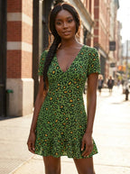 Woman wearing a green leopard print v-neck mini dress on a sunny city street