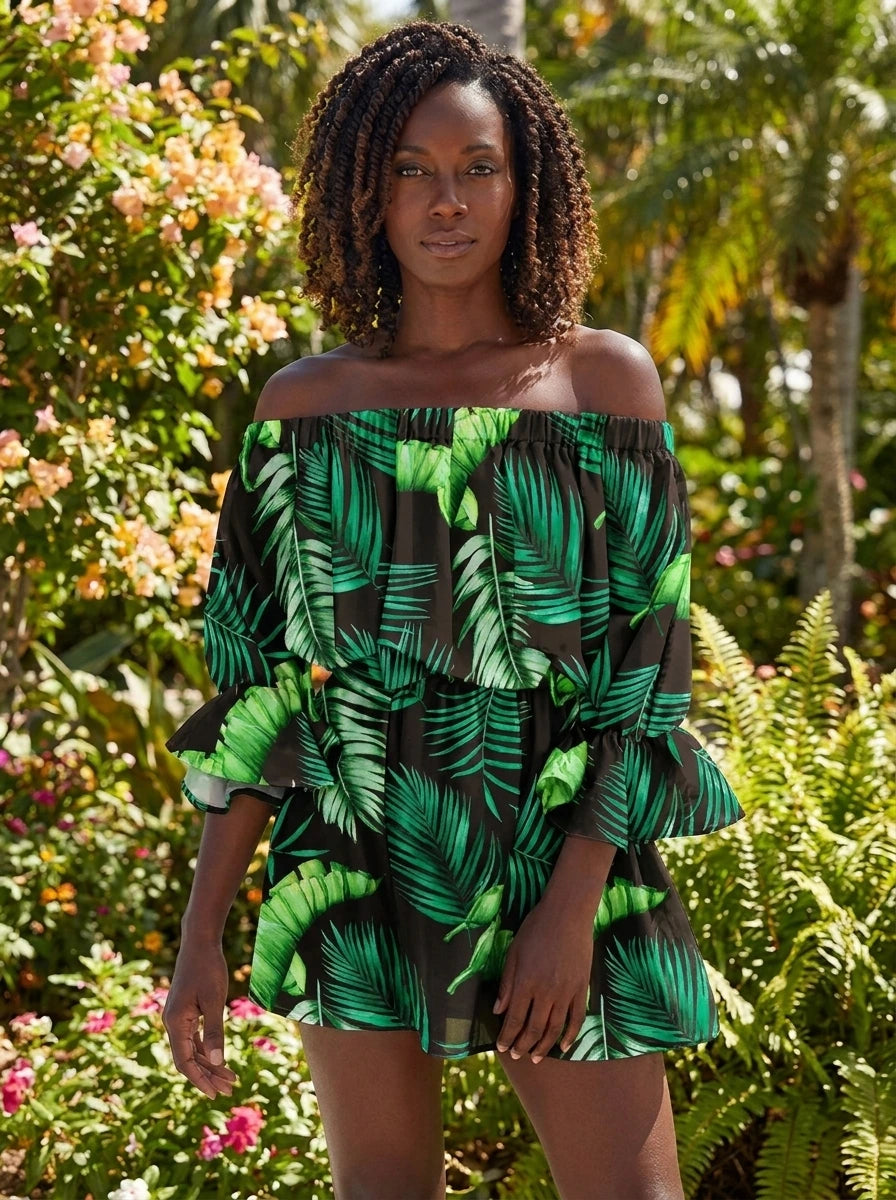 Woman wearing a green tropical palm print off-shoulder mini dress in a sunlit garden