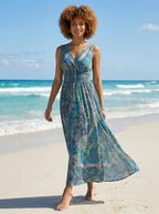 Woman wearing a teal and blue paisley print sleeveless maxi dress on a sunny beach