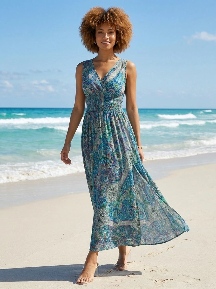 Woman wearing a teal and blue paisley print sleeveless maxi dress on a sunny beach