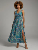 Woman wearing a teal and blue paisley print sleeveless maxi dress in a studio setting