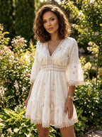 Woman wearing a white crochet lace boho dress in a sunlit garden