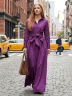 Woman wearing a purple bow detail maxi dress, walking on a city street