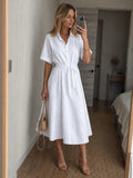 Woman wearing a white button-front waist tie midi dress - studio photo