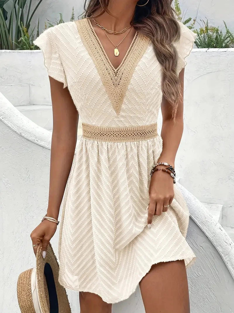 Woman wearing a beige chiffon short sleeve v-neck dress - lifestyle photo