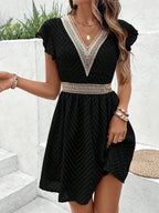 Woman wearing a black chiffon short sleeve v-neck dress - lifestyle photo