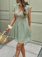 Woman wearing a green chiffon short sleeve v-neck dress - lifestyle photo