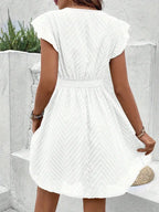 Woman wearing a white chiffon short sleeve v-neck dress - outdoor lifestyle photo