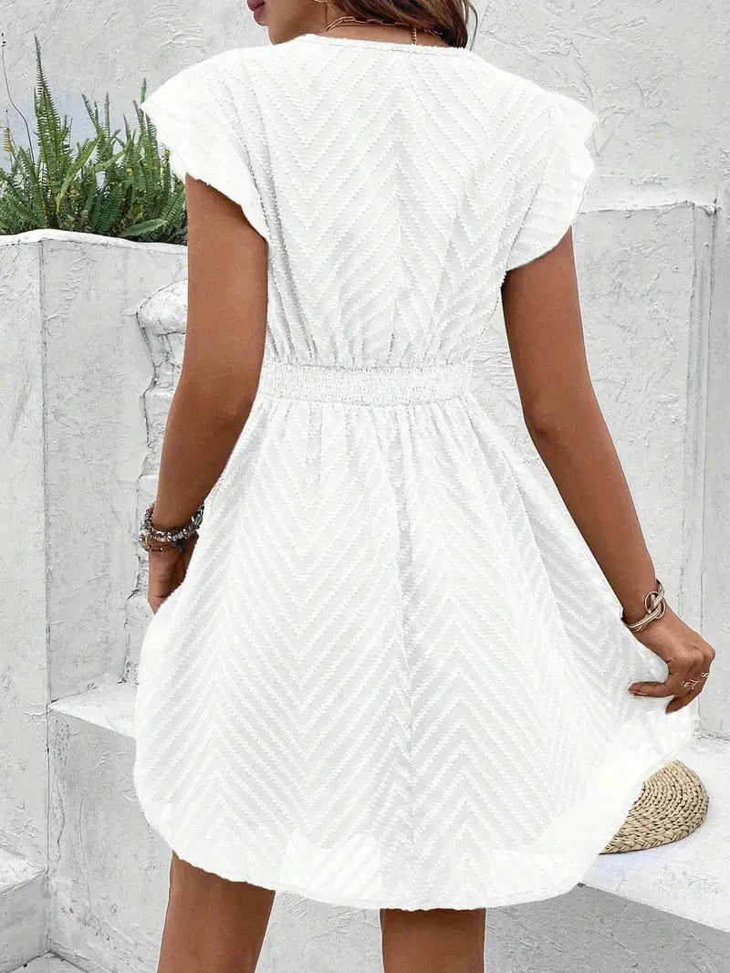 Woman wearing a white chiffon short sleeve v-neck dress - outdoor lifestyle photo