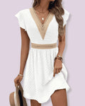 Woman wearing a white chiffon short sleeve v-neck dress - studio photo