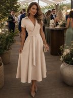 Woman wearing a beige collared wrap waist midi dress - lifestyle photo