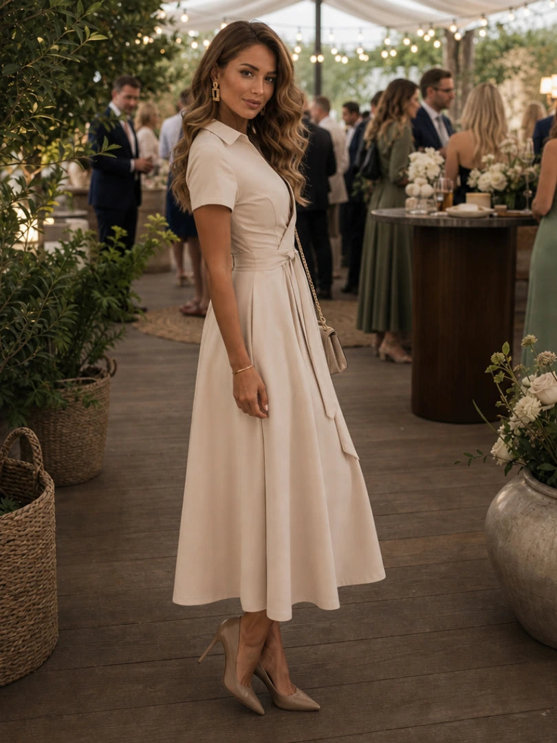 Woman wearing a beige collared wrap waist midi dress - lifestyle photo