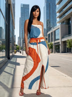 Woman wearing a white color-blocked strapless maxi dress on a city street