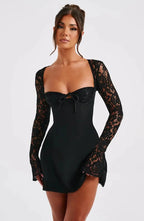 Woman wearing a black corset back long sleeve mini dress - studio photo