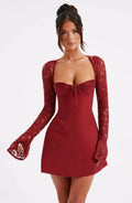 Woman wearing a red corset back long sleeve mini dress - studio photo