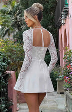 Woman wearing a white corset back long sleeve mini dress - outdoor lifestyle photo