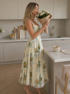Woman wearing a beige corset style structured bodice midi dress - studio photo