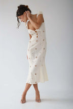 Woman wearing a white cut-out fitted midi dress - studio photo