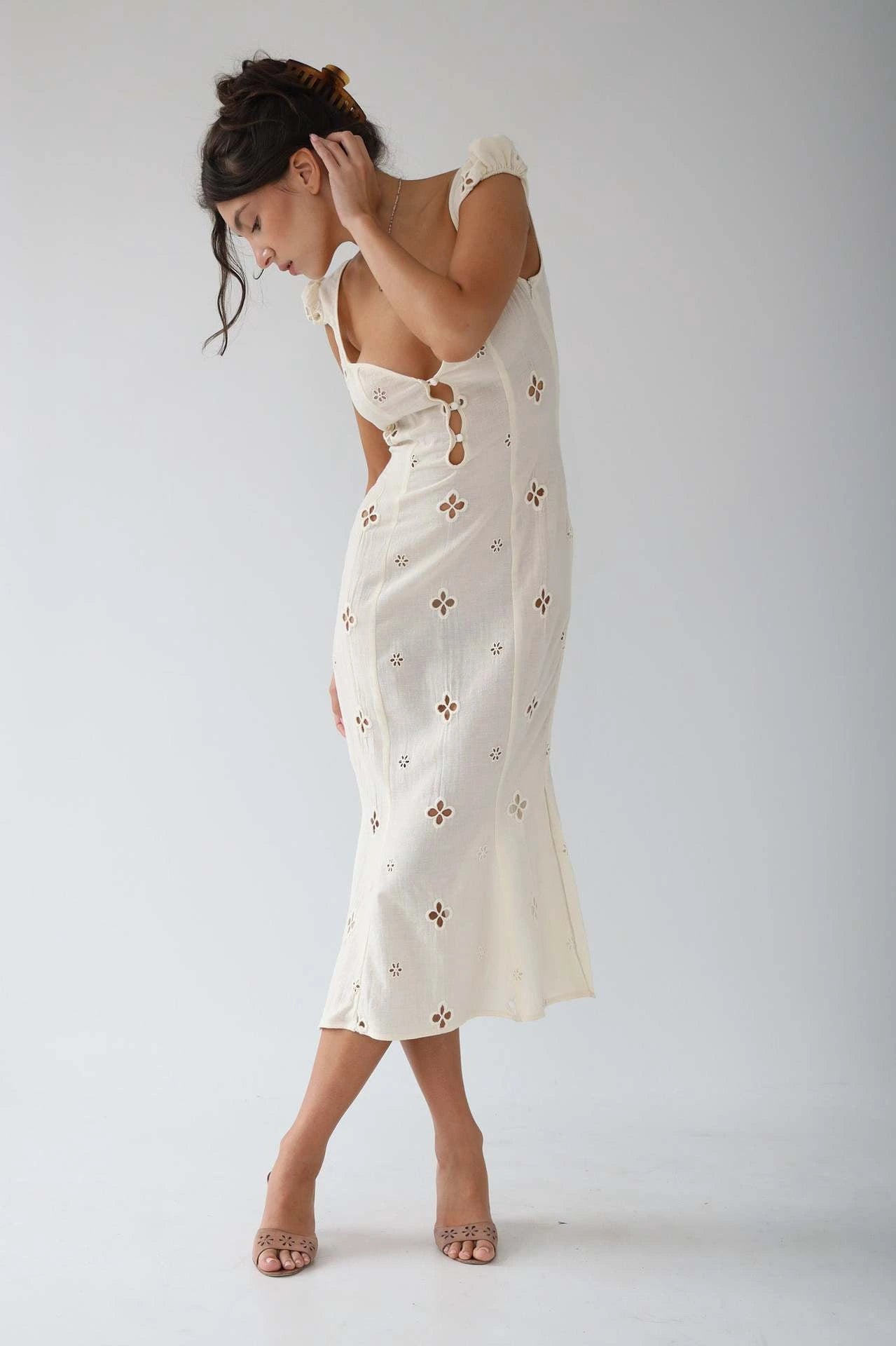 Woman wearing a white cut-out fitted midi dress - studio photo