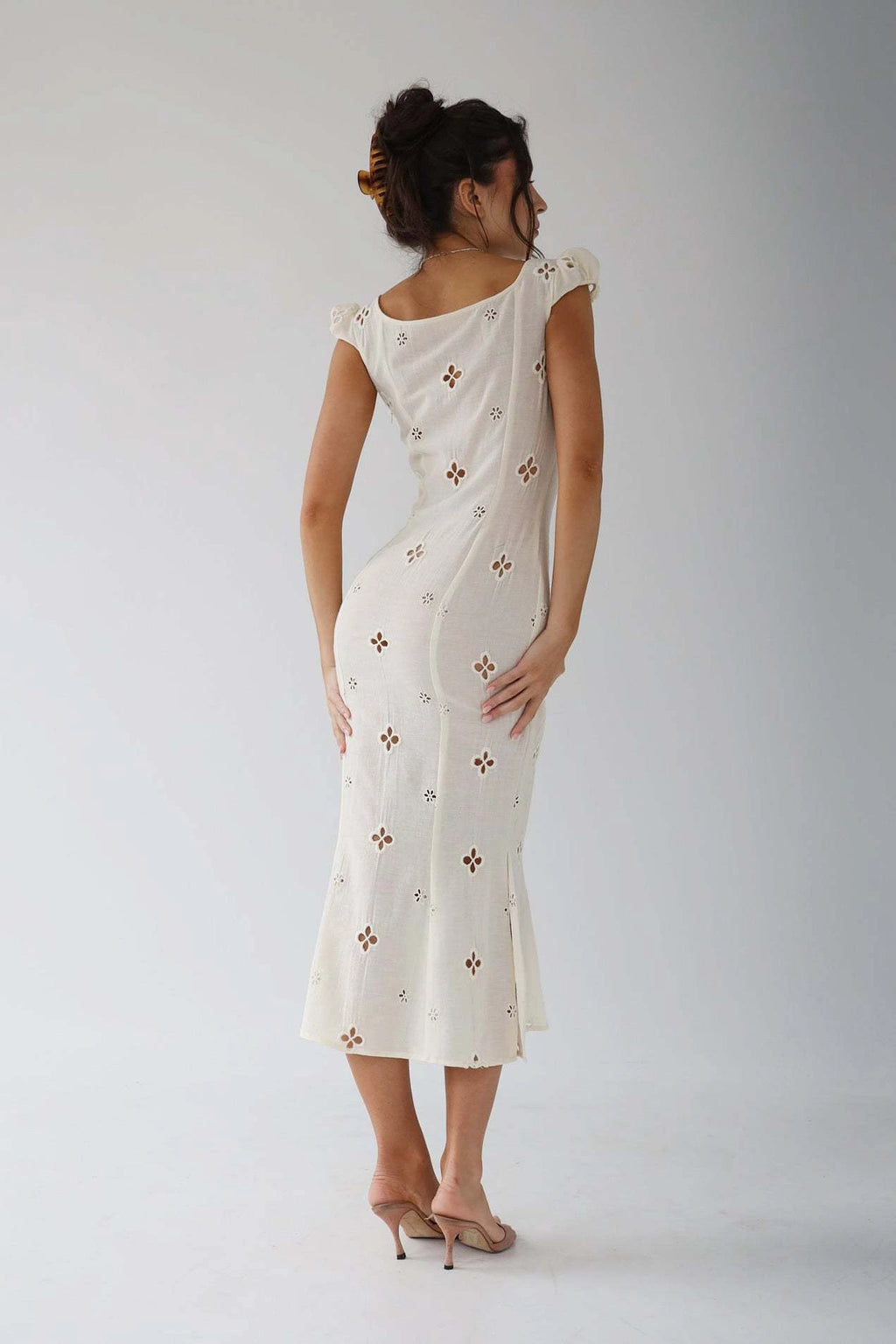 Woman wearing a white cut-out fitted midi dress - studio photo