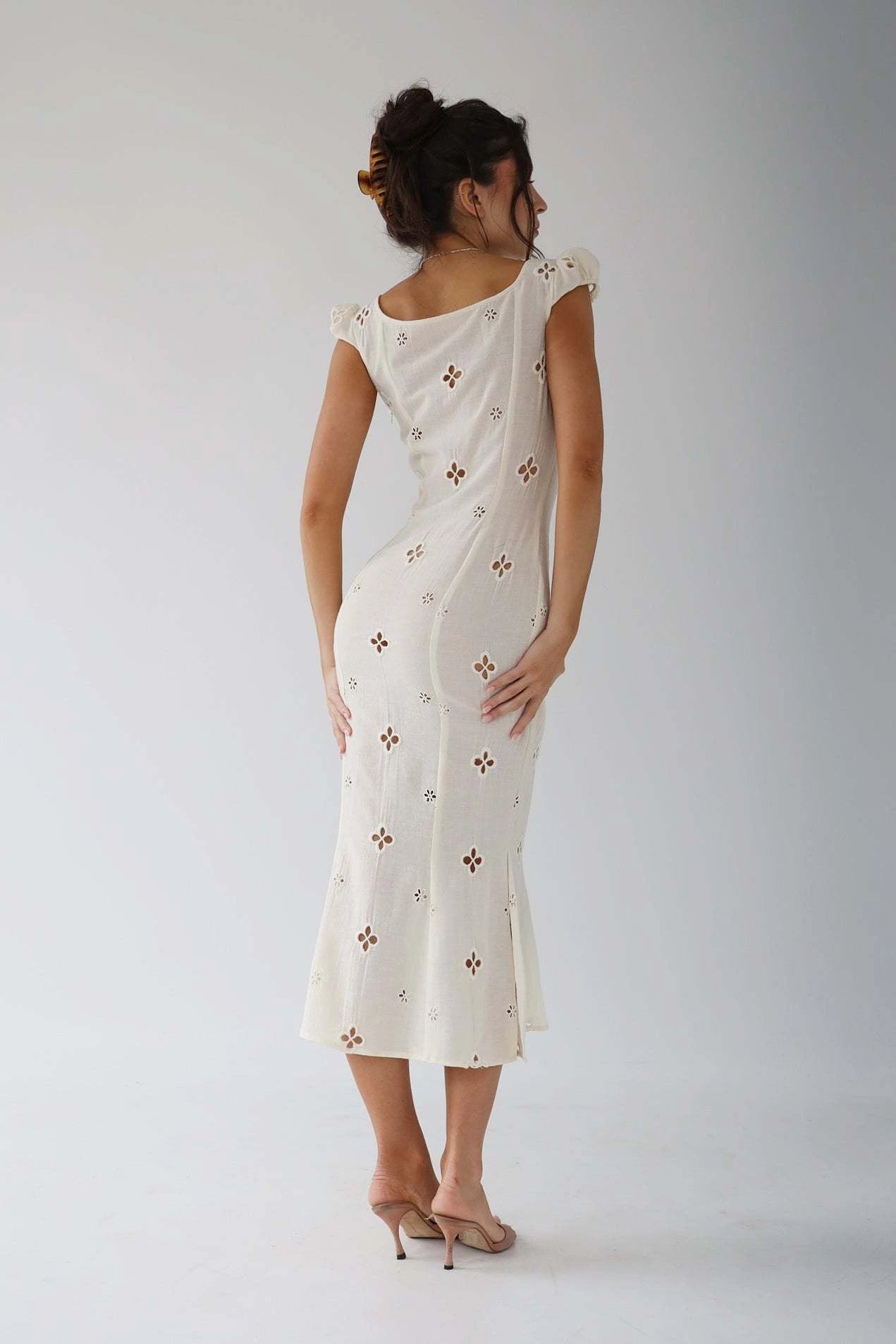 Woman wearing a white cut-out fitted midi dress - studio photo