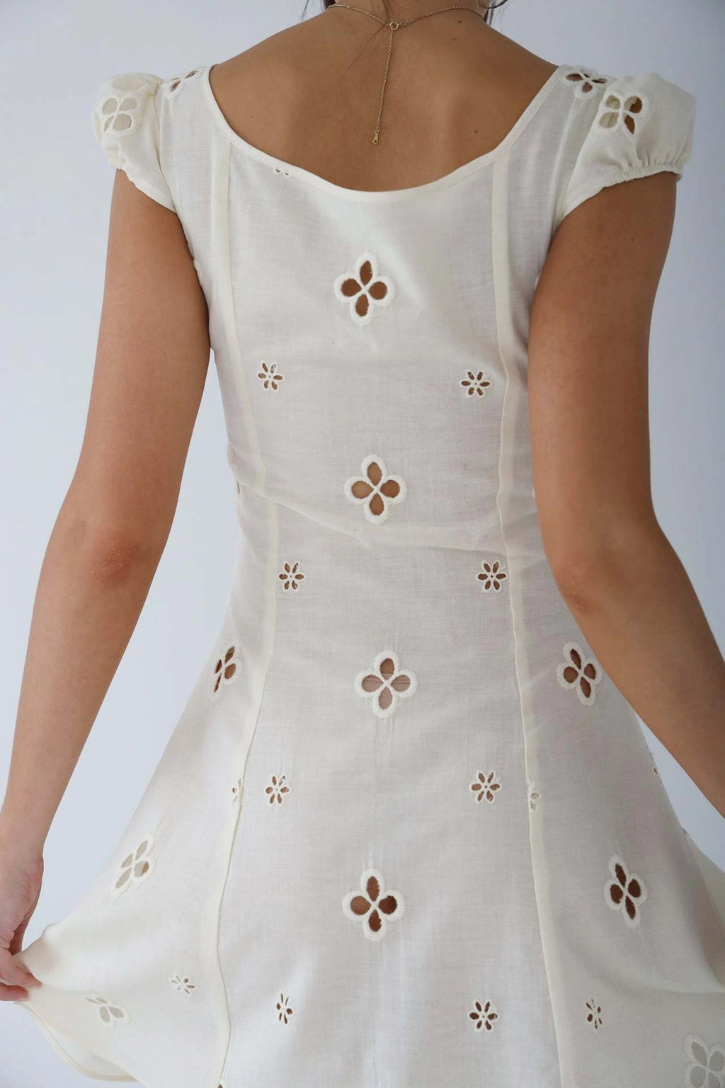 Woman wearing a white cut-out fitted midi dress - studio photo