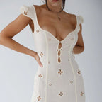 Woman wearing a white cut-out fitted midi dress - studio photo