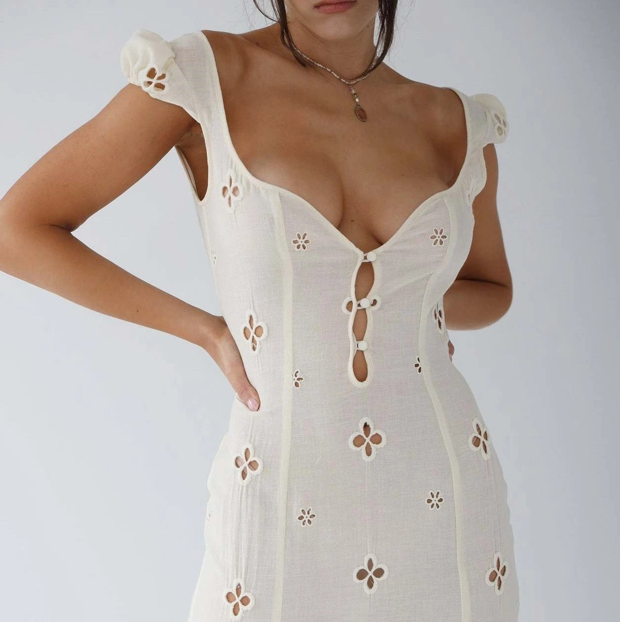 Woman wearing a white cut-out fitted midi dress - studio photo
