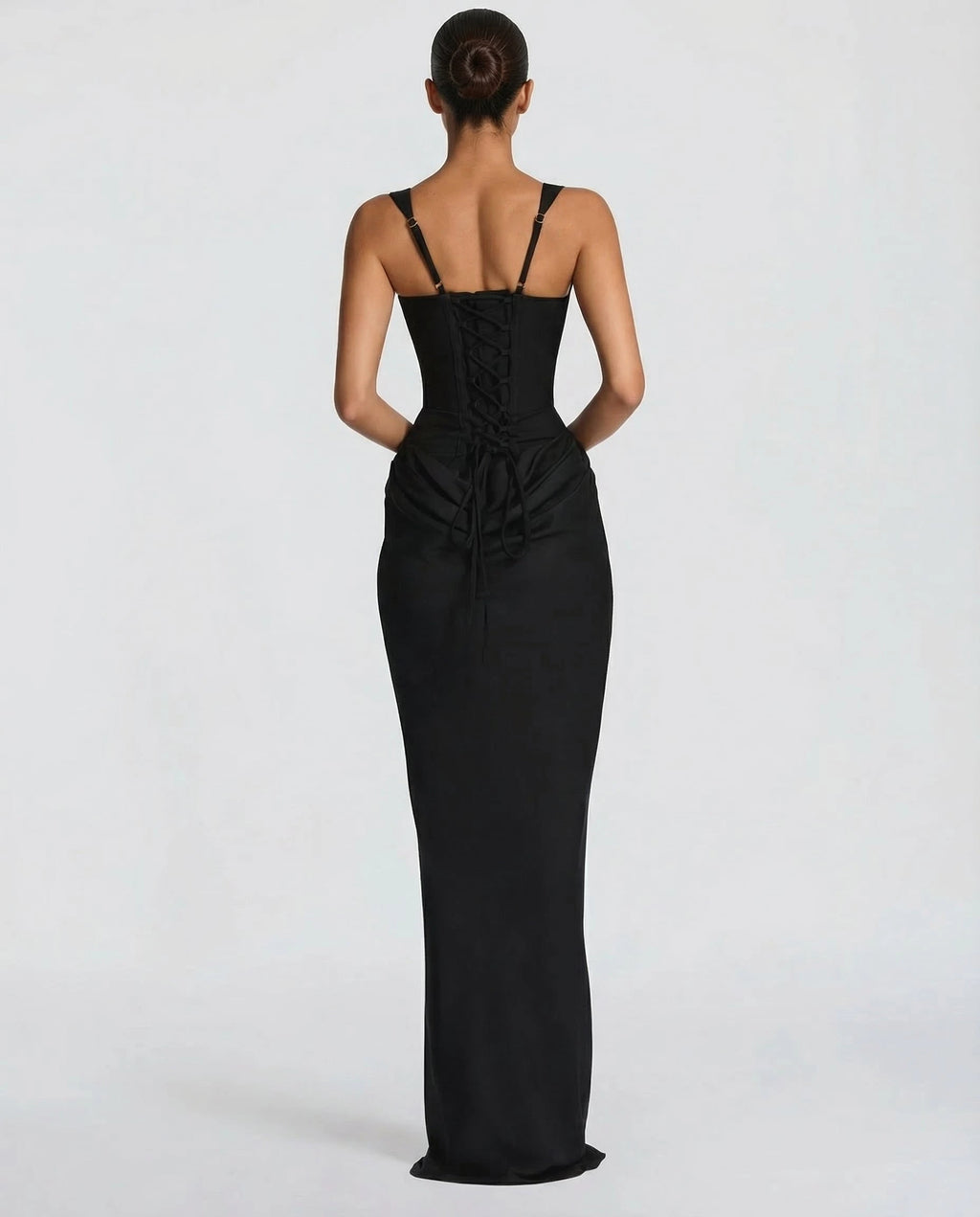 Woman wearing a black draped waist sculpted maxi dress - studio photo
