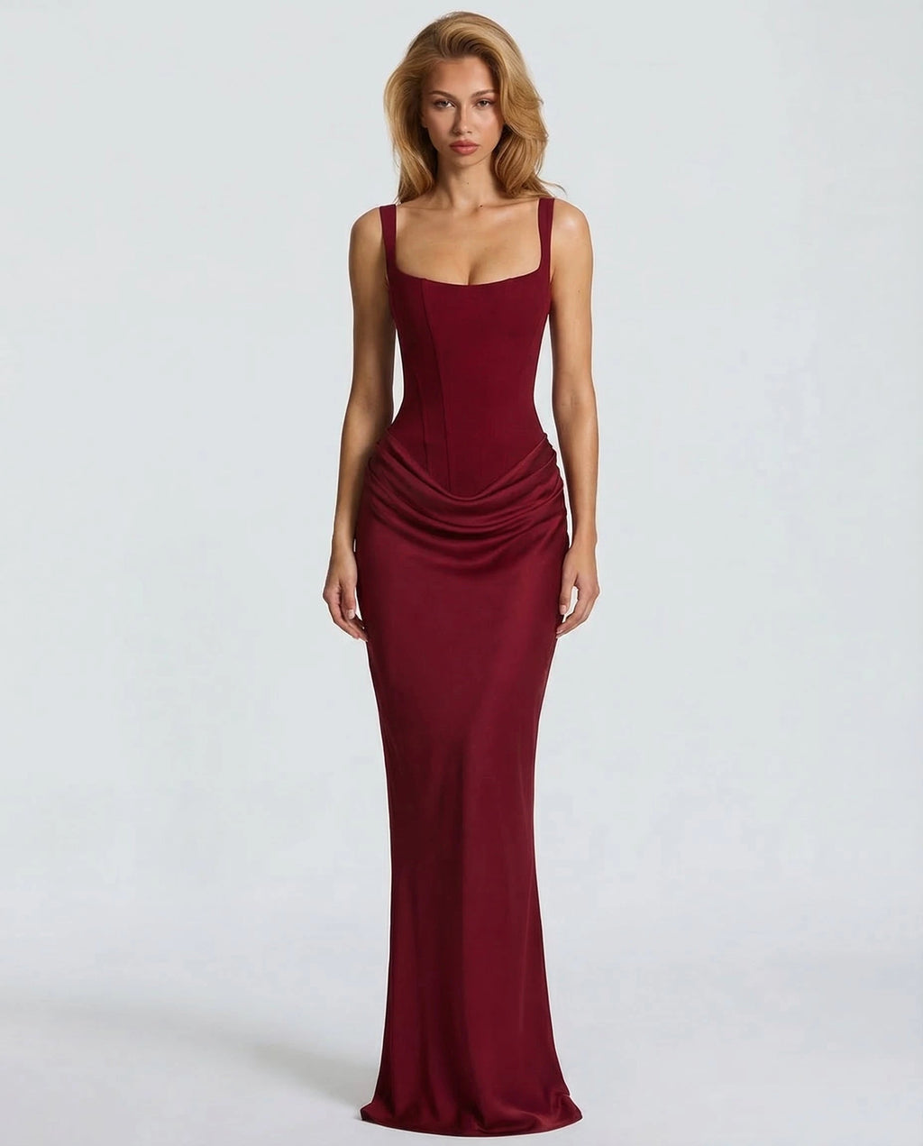 Woman wearing a red draped waist sculpted maxi dress - studio photo