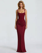 Woman wearing a red draped waist sculpted maxi dress - studio photo