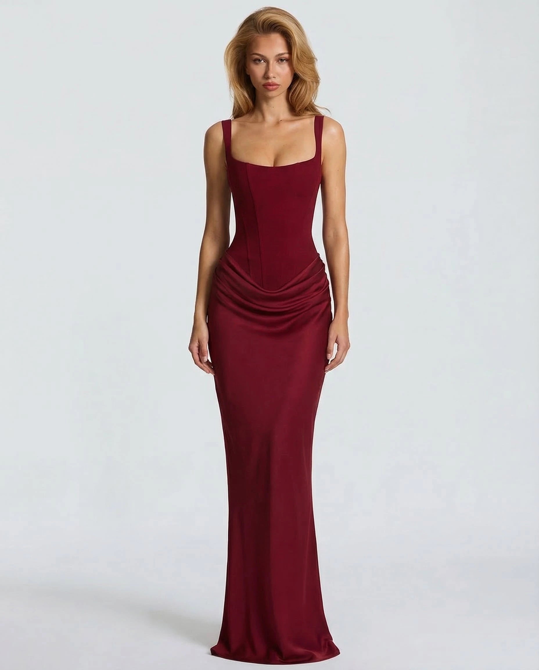 Woman wearing a red draped waist sculpted maxi dress - studio photo