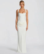 Woman wearing a white draped waist sculpted maxi dress - studio photo