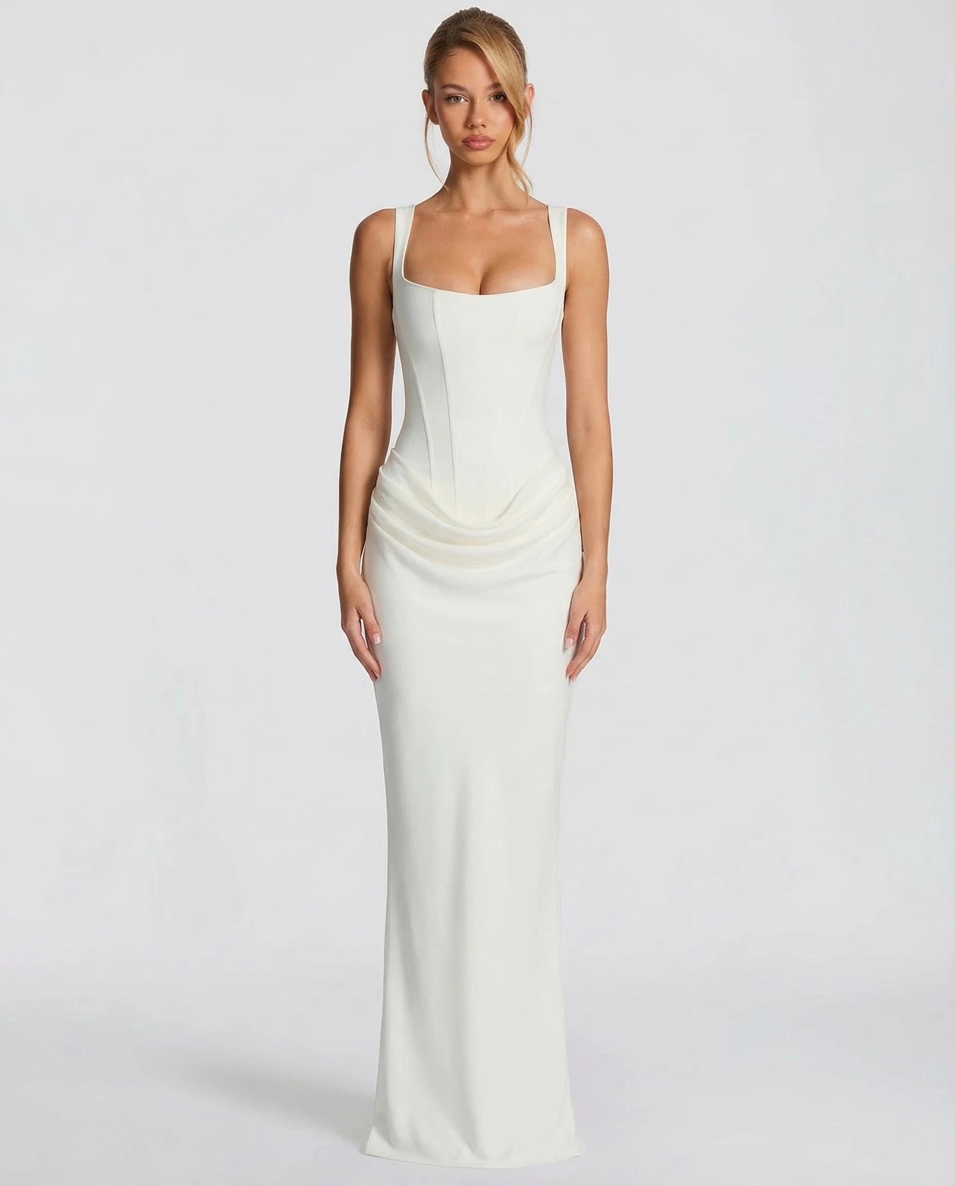 Woman wearing a white draped waist sculpted maxi dress - studio photo