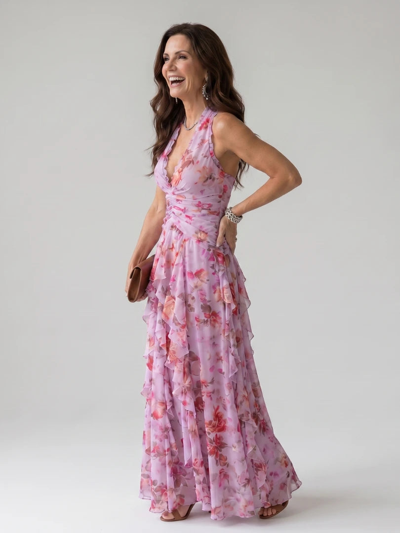 Woman wearing a pink floral halter neck ruched maxi dress - studio photo