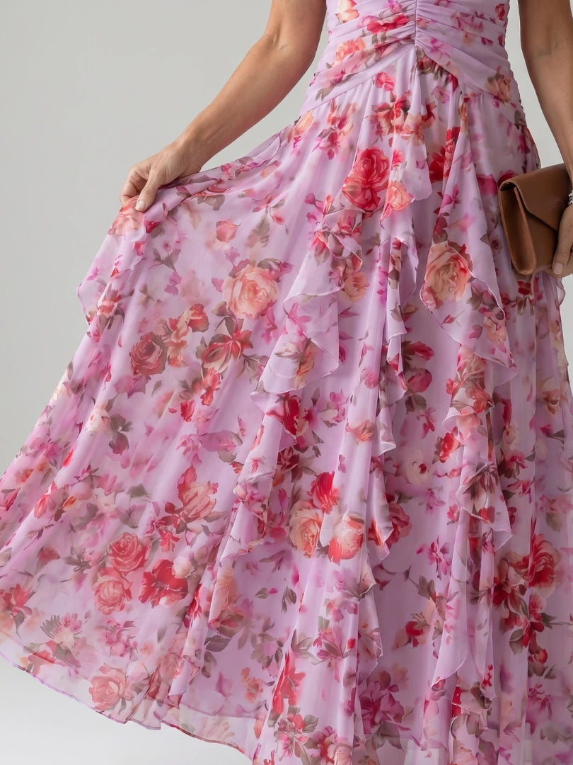 Woman wearing a pink floral halter neck ruched maxi dress - studio photo