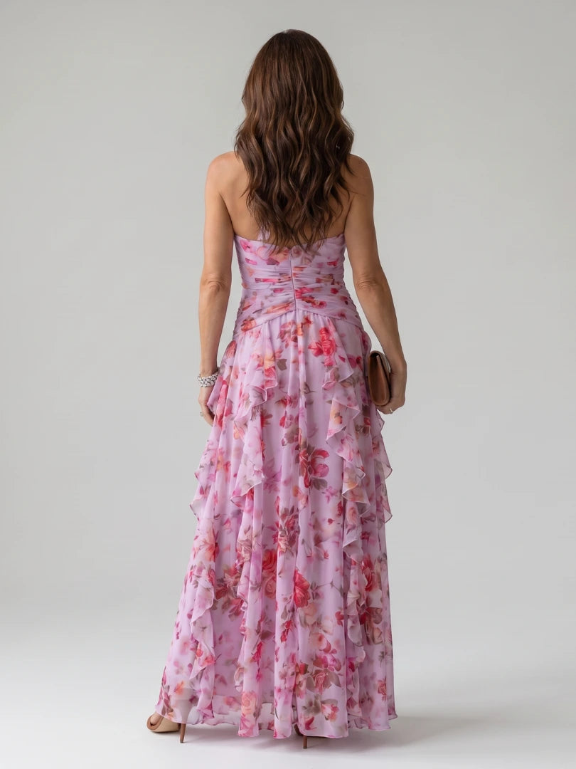 Woman wearing a pink floral halter neck ruched maxi dress - studio photo