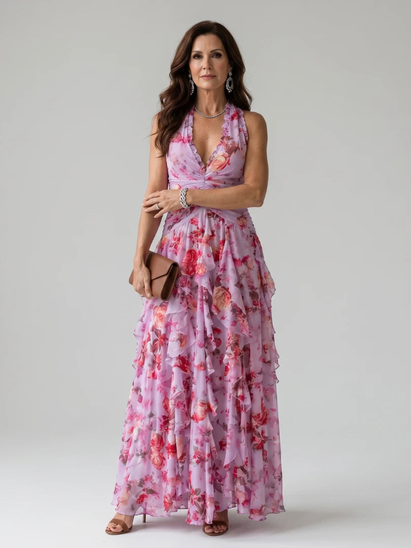 Woman wearing a pink floral halter neck ruched maxi dress - studio photo
