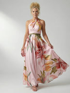 Woman wearing a pink floral halter tie-neck maxi dress - studio photo