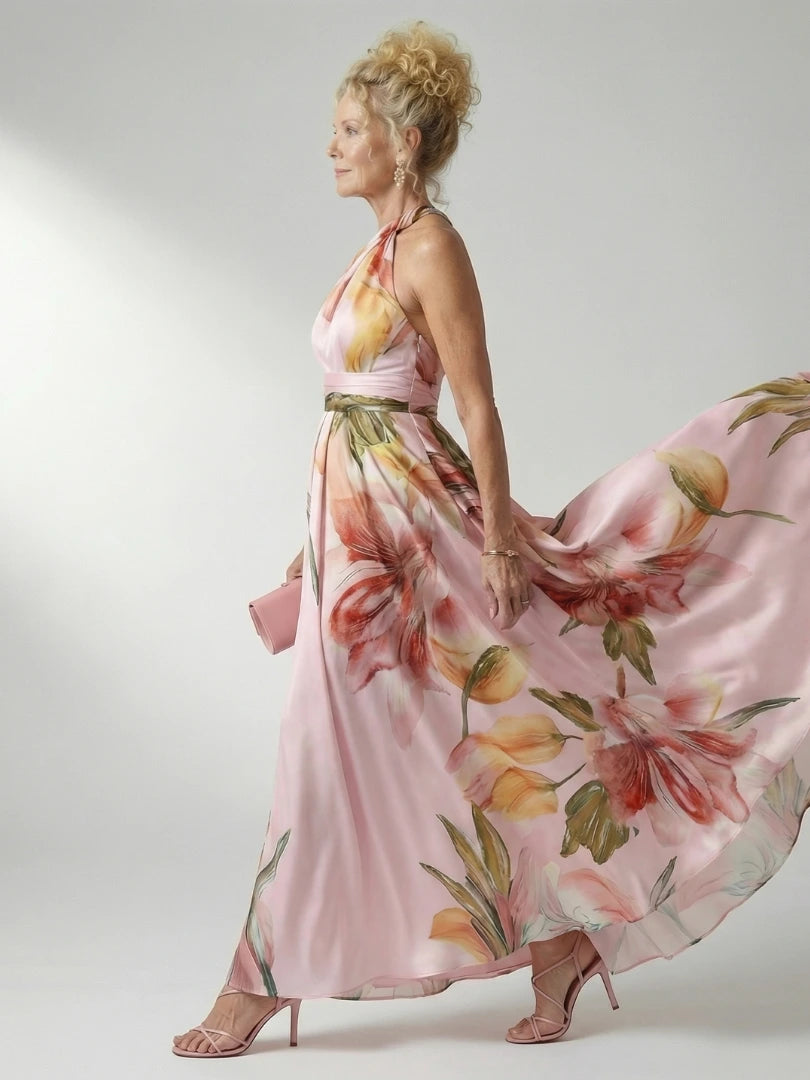 Woman wearing a pink floral halter tie-neck maxi dress - studio photo