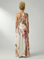 Woman wearing a purple floral halter tie-neck maxi dress - studio photo