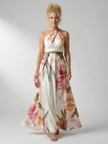 Woman wearing a white floral halter tie-neck maxi dress - studio photo